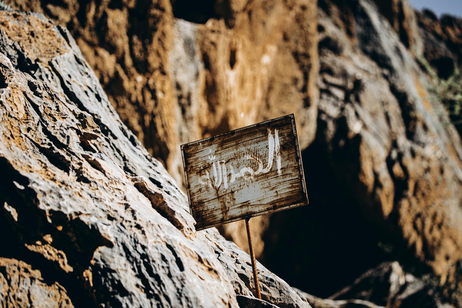 Stary drogowskaz na skalistym pustynnym szlaku w Omanie