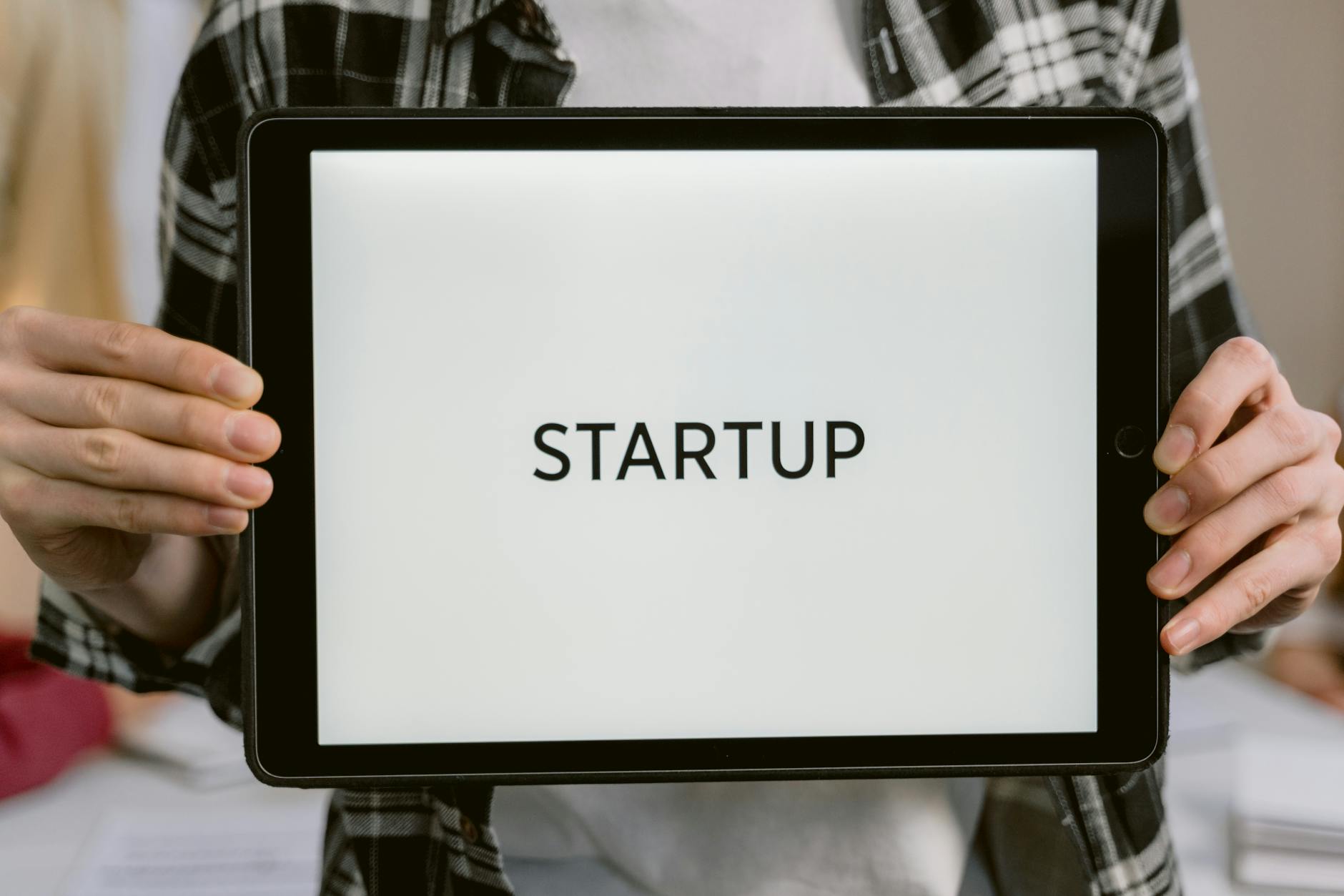 Osoba trzyma tablet z napisem STARTUP jako symbol nowego biznesu tech
