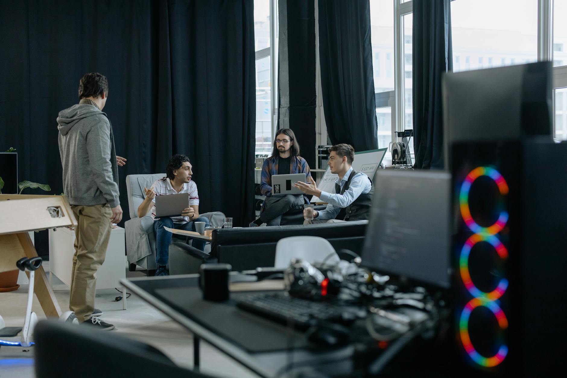 Zespół startupowy omawia projekt technologiczny przy laptopach w biurze