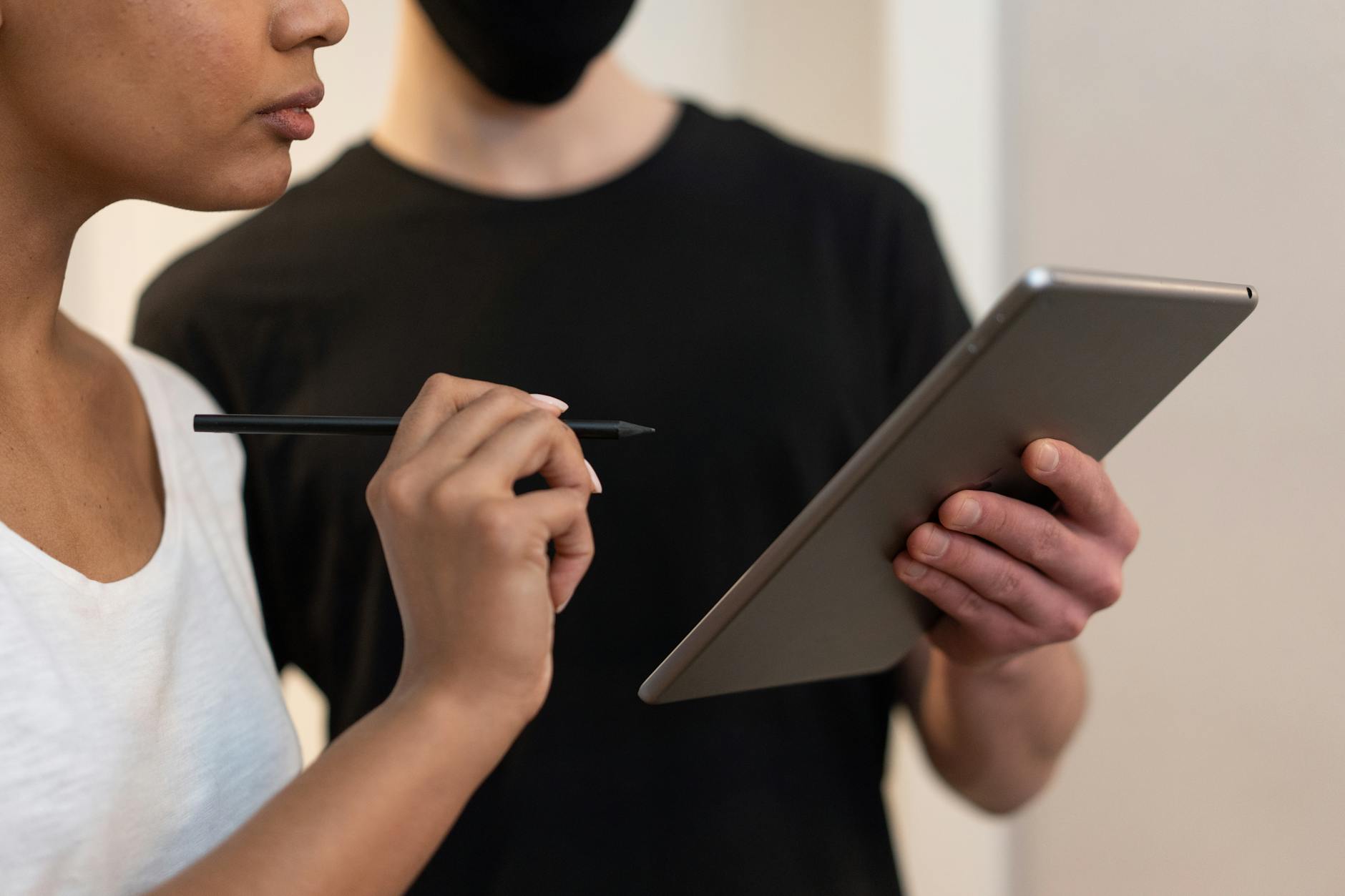 Dwie osoby analizują dane na tablecie za pomocą rysika