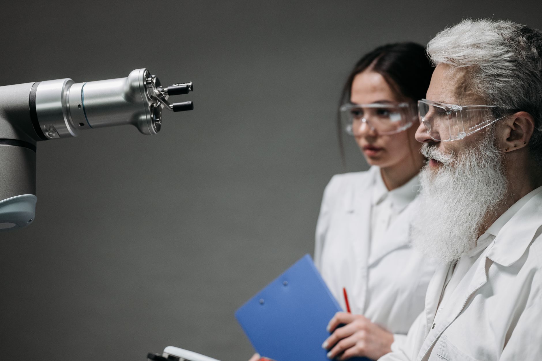 Dwóch naukowców w laboratorium analizuje ruchy ramienia robota