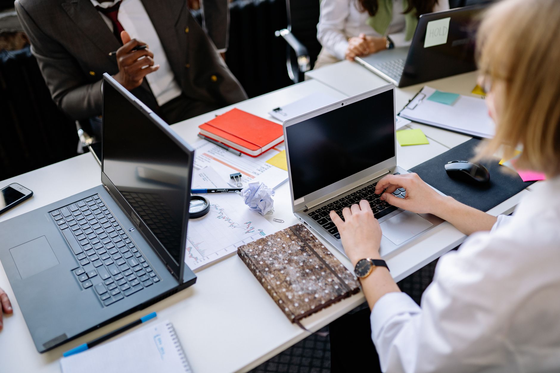 Zespół omawia projekty na laptopach w nowoczesnym biurze