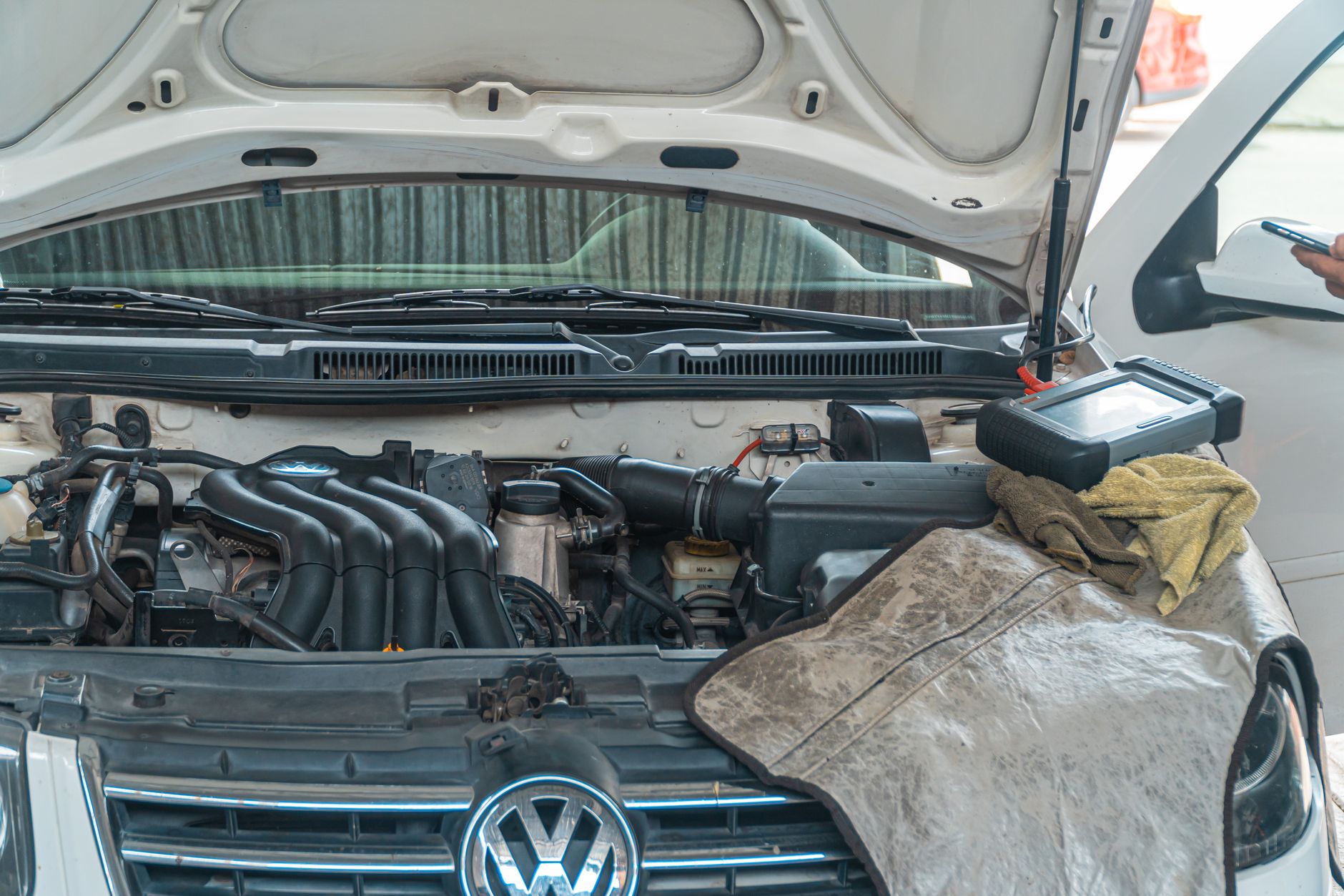 Mechanik diagnozuje silnik Volkswagena przy użyciu narzędzi w garażu